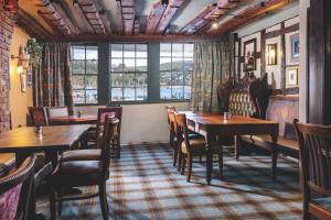 a restaurant with tables and chairs and a window at The Royal Castle Hotel in Dartmouth