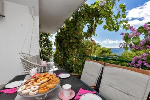 a table with a tray of pastries on a balcony at Apartmani Antonela in Drasnice