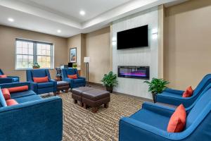 a waiting room with blue chairs and a flat screen tv at Comfort Inn in Brewster