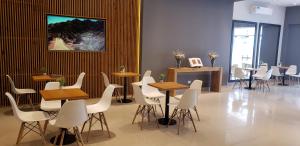 a waiting room with tables and chairs and a painting on the wall at Urquiza Suites Salta in Salta