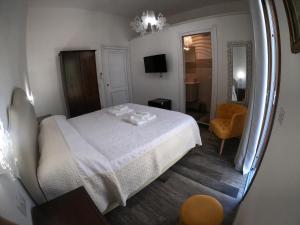 een slaapkamer met een wit bed en een spiegel bij Villa Sari affitta camere in La Caletta