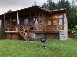 uma casa grande com um grelhador no quintal em Katarino Mountain House em Razlog