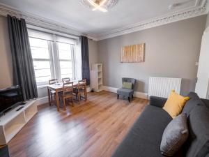 ein Wohnzimmer mit einem Sofa und einem Tisch in der Unterkunft New Superhost Listing: Bright flat nr. University in Dundee