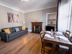 a living room with a table and a couch at New Superhost Listing: Bright flat nr. University in Dundee