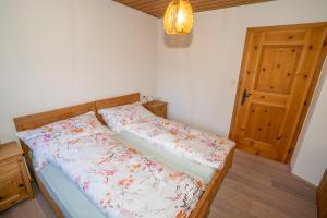 een kleine slaapkamer met een bed met bloemen erop bij Chasa Nogler - Ferienwohnung in Ramosch