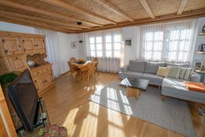 ein Wohnzimmer mit einem Sofa und einem Tisch in der Unterkunft Chasa Nogler - Ferienwohnung in Ramosch