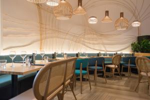 a dining room with tables and chairs and chandeliers at Novotel Nice Arenas Aeroport in Nice +190 photos