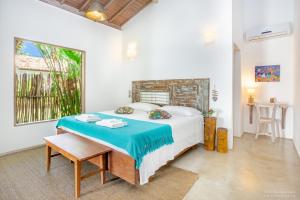 a bedroom with a bed and a table and a window at Pousada Casotas in Pôrto de Pedras