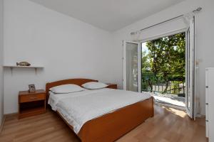 a bedroom with a bed and a large window at Apartmani Antonela in Drasnice