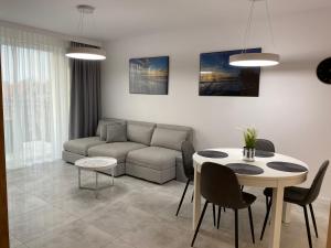 ein Wohnzimmer mit einem Sofa und einem Tisch in der Unterkunft Bel Mare Comfort 305 Apartament in Misdroy