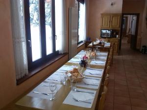 a long table with white plates and wine glasses at Casa San Francesco in Bardonecchia