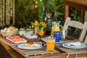 una mesa de madera con alimentos para el desayuno y bebidas. en Pousada Casotas en Pôrto de Pedras