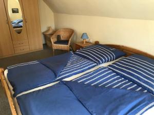 Schlafzimmer mit einem Bett mit blauen und weißen Kissen in der Unterkunft Ferienwohnung Heikendorf in Heikendorf