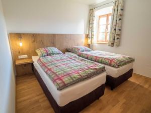 two twin beds in a room with a window at Heimhilgerhof in Seeon