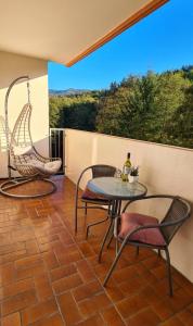 een patio met 2 stoelen en een tafel op een bakstenen vloer bij Ferienwohnung am Waldsee mit Schwimmbad in Gernsbach
