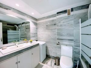 uma casa de banho com um WC, um lavatório e um espelho. em Ricardo Soriano 16 - EaW Homes em Marbella