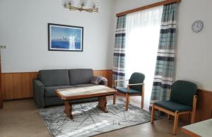 ein Wohnzimmer mit einem Sofa und 2 Stühlen in der Unterkunft Appartements Stadt Wien in Bad Hofgastein