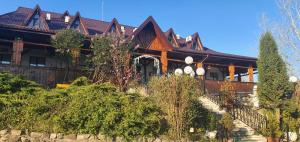 ein großes Holzhaus mit Treppe davor in der Unterkunft Casa Boiereasca in Iaşi