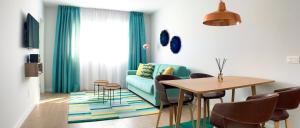sala de estar con sofá azul y mesa en Sea to Sky Suites - Mijas Pueblo en Mijas
