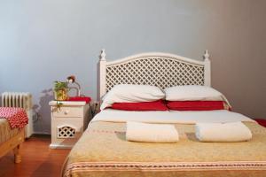 a bedroom with a white bed with red pillows at Hostel Home in Mexico City