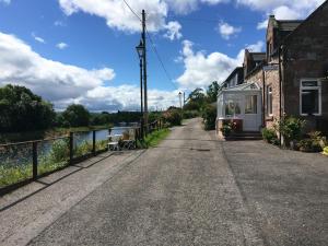 a road next to a house and a river at Sealladh Sona in Inverness