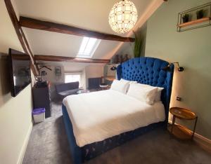 a bedroom with a large bed with a blue headboard at The Hive at Poppi-Red in Hawkshead