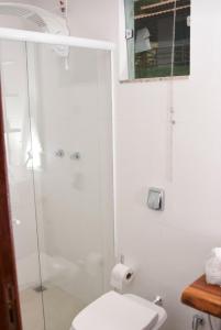 a bathroom with a toilet and a glass shower at Raposo Vale Encantado Pousada in Antônio Prado