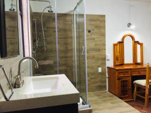 y baño con lavabo y ducha. en Hotel Cazomalli Oaxaca en Oaxaca de Juárez