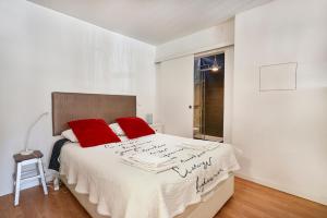 een witte slaapkamer met rode kussens op een bed bij Renovated Charming Apartment, By TimeCooler in Lissabon