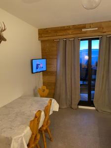 a bedroom with a bed and a sliding glass door at Studio résidence les vans in Chamrousse