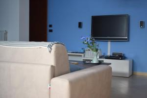 a living room with a couch and a tv at Journey House in Manduria