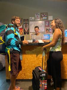 a man and a woman standing at a cash register at A Coroa Hostel & Suites in Arraial do Cabo