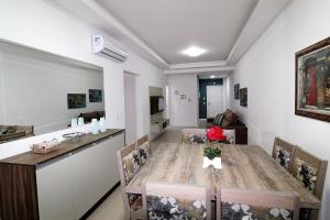 cocina y comedor con mesa y sillas en 1067 - Apartamento para locação em Bombinhas com 03 suítes, en Bombinhas