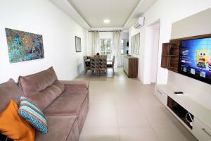 sala de estar con sofá y TV de pantalla plana en 1067 - Apartamento para locação em Bombinhas com 03 suítes, en Bombinhas