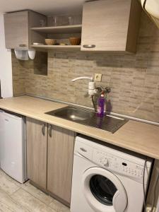 a kitchen with a washing machine and a sink at Апартамент 27 юли in Varna City
