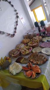 a table topped with lots of different types of food at Pousada Bela Vista in Penedo