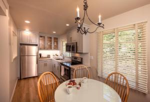a kitchen with a table and chairs and a refrigerator at Horizon Inn & Ocean View Lodge in Carmel