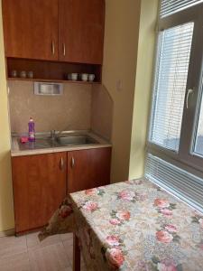 una cocina con fregadero y una mesa con motivos florales en АПАРТМЕНТ 27 юли 2, en Varna
