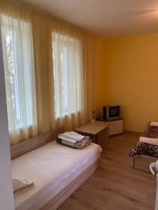 Una habitación con una cama y un televisor y ventanas. en АПАРТМЕНТ 27 юли 2, en Varna 23 fotos más