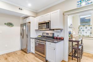 una cucina con armadi bianchi e frigorifero in acciaio inossidabile di Mariner's Rest East ad Anacortes