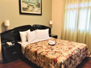 Un dormitorio con una cama con una colcha floral. en Hostal Carlos Tenaud, en Lima