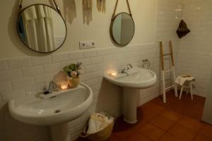 a bathroom with two sinks and two mirrors at Casa Rural Priorato San Martín in Amés