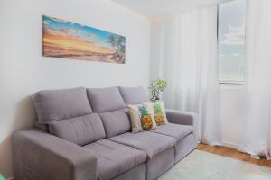 a gray couch in a living room with a painting at Golden Sea Horizon in Funchal