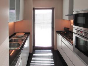 a kitchen with a hallway leading to a door at Panoramic in Travel, Parque das Nações in Lisbon