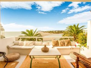 uma sala de estar com um sofá e vista para a praia em Belvilla by OYO Apartment in SAN ROQUE CADIZ em Sotogrande