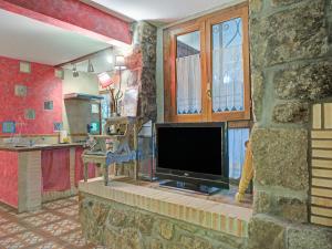 ein Wohnzimmer mit einem TV an einer Steinmauer in der Unterkunft Rural apartment with Spa and common areas in Galapagar
