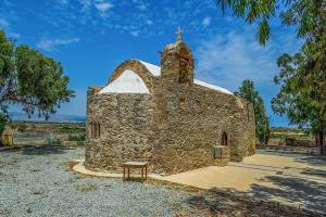 eine alte Steinkirche mit einer Bank davor in der Unterkunft LIMASSOL AKROTIRI BEACH VINE COTTAGE a in Limassol