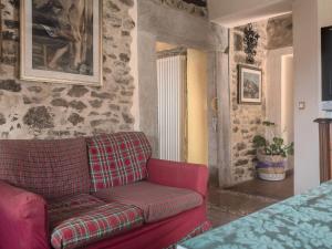 a red couch in a room with a stone wall at Soulful Holiday Home in Modena wth Garden in Modena