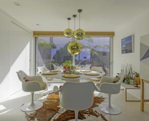 a dining room with a white table and chairs at Villa Infinity Denia in Denia