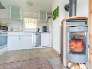 cocina con chimenea en el medio de una habitación en Holiday home with terrace next to the forest, en Allrode